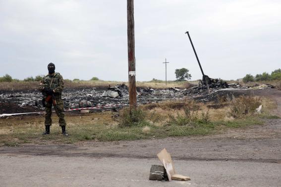 A pro-Russian separatist stands on guard at the crash site of Malaysia Airlines Flight MH17, near the settlement of Grabovo in the Donetsk region July 19, 2014. REUTERS/Maxim Zmeyev
