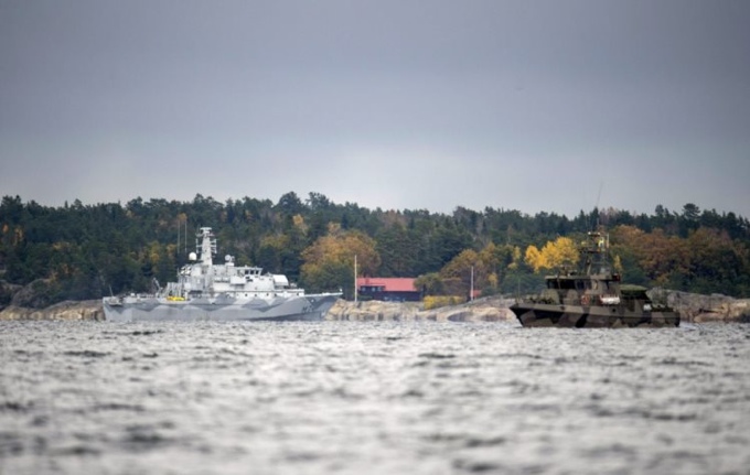 The Swedish minesweeper HMS Kullen and a guard boat are seen in the search for suspected 'foreign underwater activity' at Namdo Bay, Stockholm October 21, 2014. [TT News Agency]