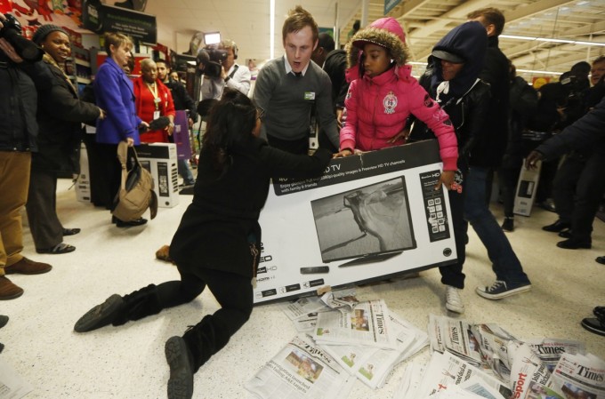 Shoppers wrestle over a television as they compete to purchase retail items on "Black Friday" at an Asda superstore in Wembley