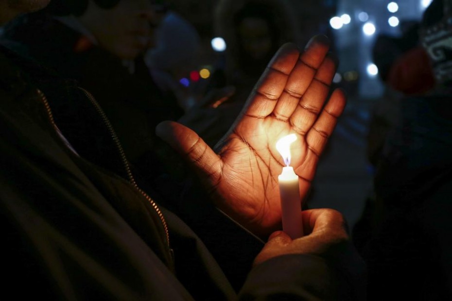 People hold candles while they take part in a rally to call for action in response to police violence, at the steps of City Hall in New York, December 12, 2014. Photo: Reuters