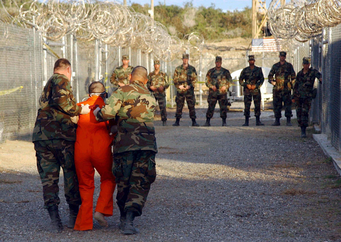 U.S. Army Military Police escort a detainee to his cell during in-processing to the temporary detention facility at Camp X-Ray in Naval Base Guantanamo Bay (Reuters)