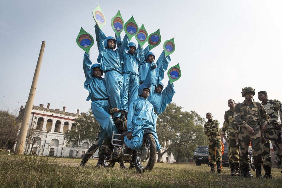 Sugit Oranv, in costume at front of bike, is part of the Indian Border Security Force’s Dare Devils motorcycle stunt team, which performs the ‘Peacock,’ honoring India's national bird. PHOTO: JESSE PESTA/THE WALL STREET JOURNAL