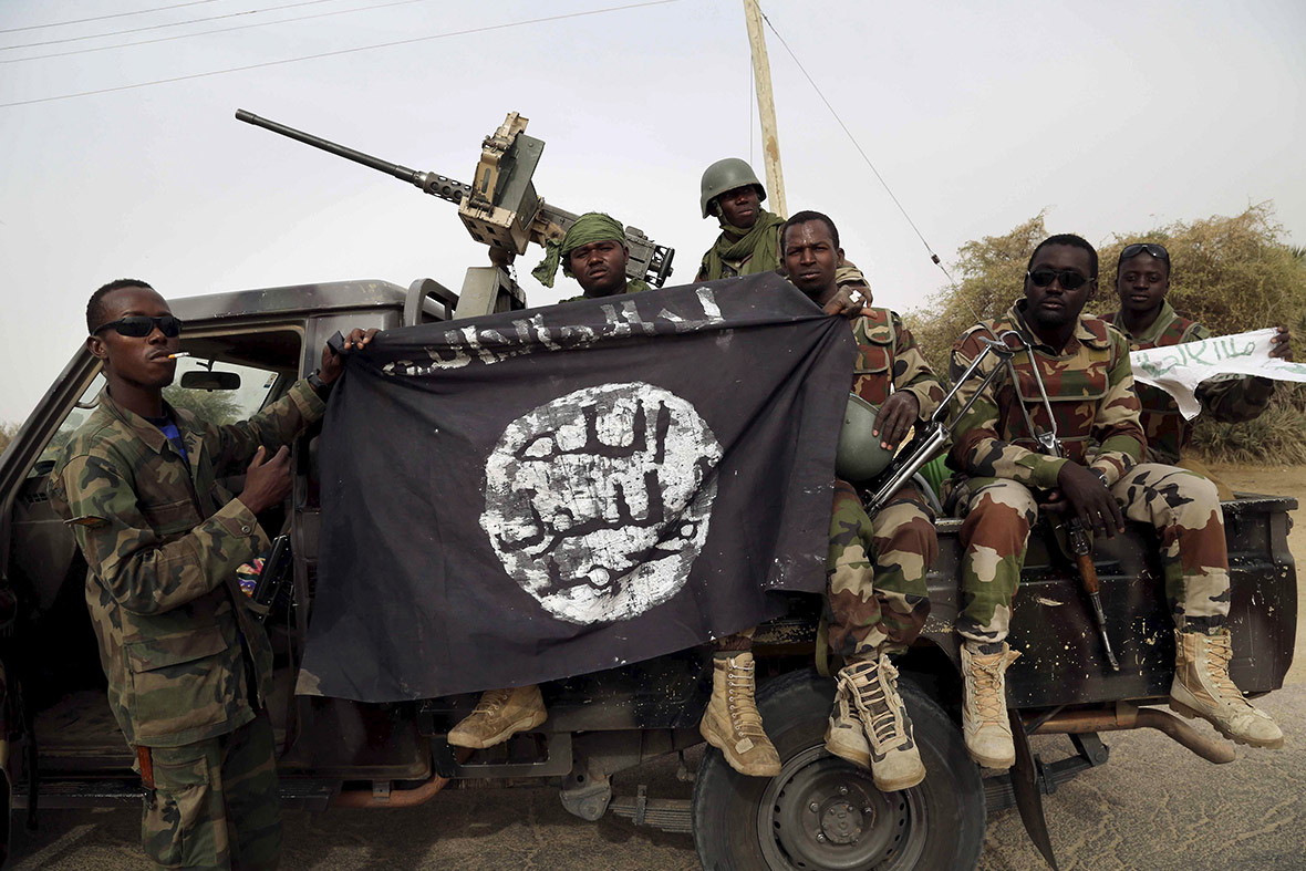 Soldiers from Niger hold up a Boko Haram flag seized in the town of Damasak, Nigeria. [Reuters] 