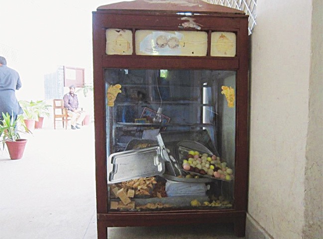 The display case at Tariq Hotel and Sweet Shop, from which the poisoned laddu were sold. Police seized the cabinet and its contents for analysis. [Dawn]