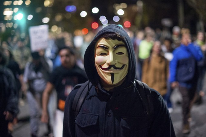 A protester wears a Guy Fawkes mask while marching against police violence in Berkeley, California December 10, 2014.  REUTERS/Noah Berger 