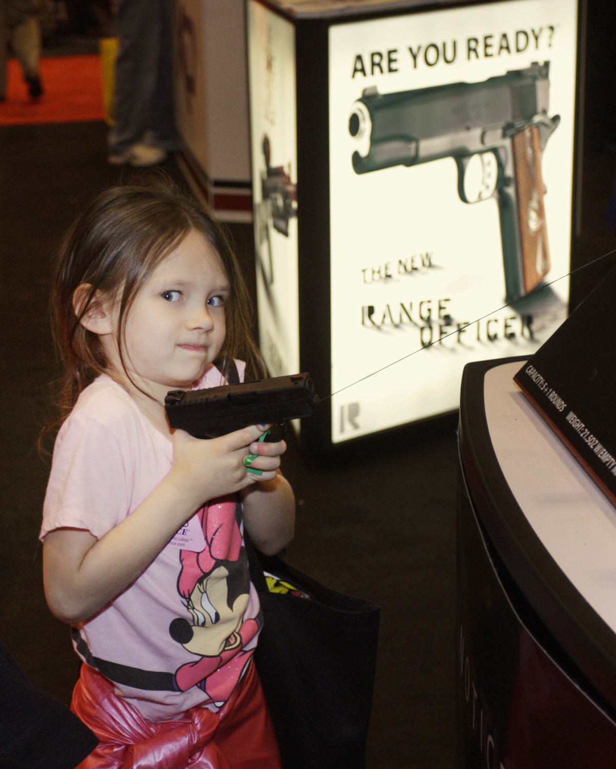 A young girl with a working handgun at an NRA convention. [REUTERS]