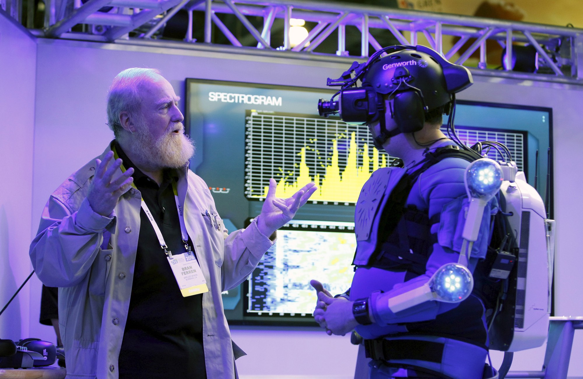 Bran Ferren (L), founder of Applied Minds, talks to a journalist dressed in an R70i aging suit. REUTERS