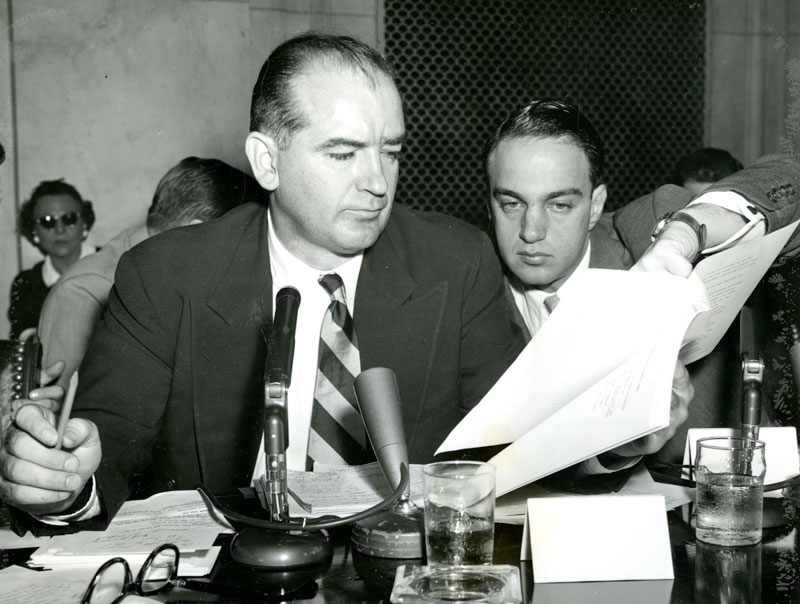 May 3, 1954: Senator Joseph McCarthy (R.Wis), is helped  by Senate Investigations subcommittee Counsel Roy Cohn, right.